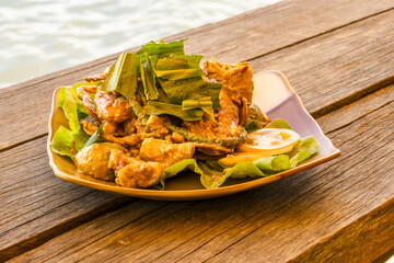 Fresh raw crab with blue claws cooking in a wok with a green pepper sauce, a specialty of Kep, Cambodia