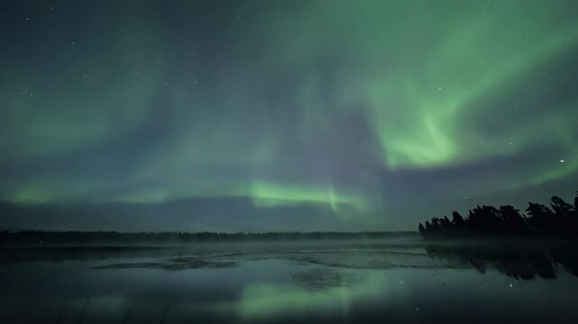 Ultra-wide angle shot of strong auroras above a still lake