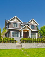 Two story stucco luxury house with nice summer  landscape in Vancouver, Canada, North America. Day time on June 2024.