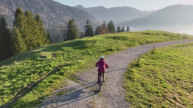 active senior woman cycling with her electric mountain bike in the Bregenz Forest mountains next to Hittisauf, Vorarlberg, Austria