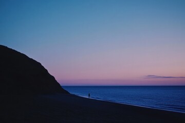 Obraz premium Solitary Figure Walking Coastal Beach Sunset