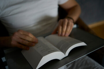 A 30-year-old man with a Bible attends an online church service, talks with the pastor