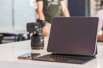 A DSLR camera is placed next to the computer on the desk as the photographer prepares to transfer the images from the camera onto the computer and edit the images for the customer.