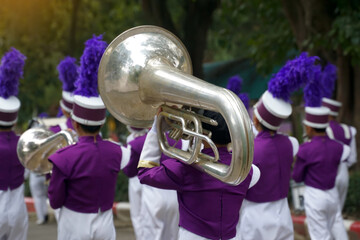 Students carry mellophones in the school orchestra procession It is a medium-pitched brass instrument used in marching bands and is used to play the French horn section in bands and orchestras.