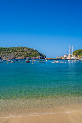 Fototapeta premium Beautiful coastal view tourist town of Port de Soller. Moored yachts, ships in harbor. Rocky coast, lighthouse. Mallorca, Spain. Balearic Islands