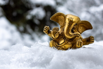 Golden Ganesha Statue in Snow-Covered Winter Scenery
