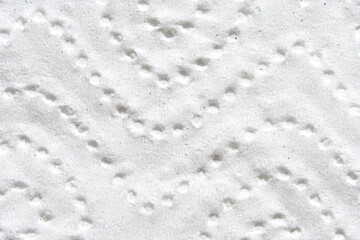 Abstract close up of white textured patterned surface with circular indentations.