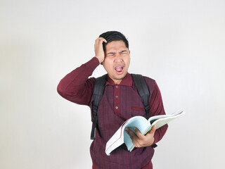 Young asian man wearing student backpack holding book confuse and wondering about question....