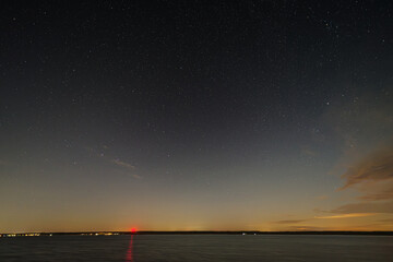 nocne niebo nad jeziorem z gwiazdami i chmurami © Henryk Niestrój