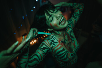 A young woman joyfully dancing at a vibrant birthday party, surrounded by colorful lights and party...