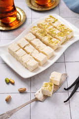 Turkish vatka - tender pashmak halva on a plate, in the form of square cubes, with a cup of Turkish tea.