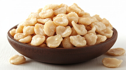 Fototapeta premium Delicious macadamia nuts in wooden bowl, perfect for snacking or baking. Their rich flavor and creamy texture make them favorite among nut lovers