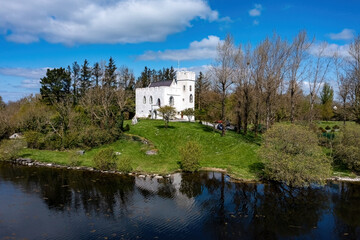 Fototapeta premium Cargin Castle on the shores of Lough Corrib, mirrored in the calm waters on a sunny day