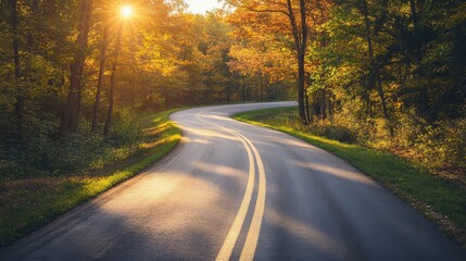 Fototapeta premium Picturesque winding country road surrounded by autumn foliage in the USA during golden hour