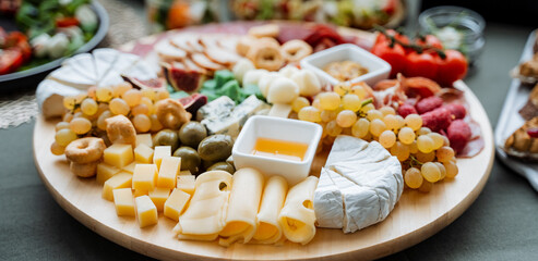 A beautifully crafted wooden cutting board is artfully topped with an assortment of delightful...