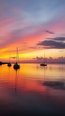 Dusk settles over Mobile Bay with stunning sailboats reflecting vibrant colors in the water