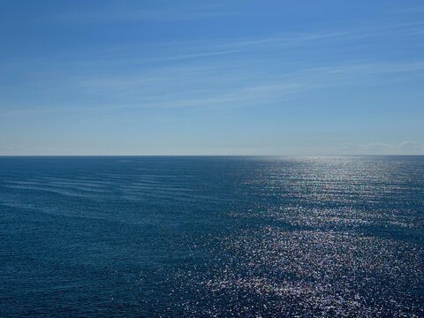 Open sea blue shiny water and sunny sky horizon