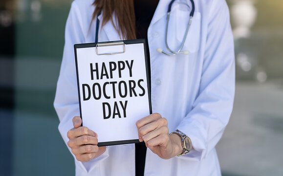 Happy Doctors Day text with document brown envelope and stethoscope isolated on office desk.