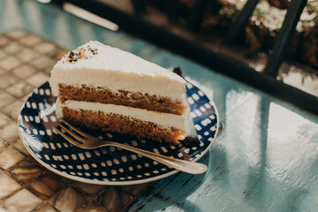 Delicious cake on a plate in a cafe. Daylight. Close up.