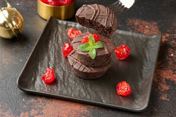 Freshly baked chocolate brownies decorated with sweet cherries and sprigs of mint