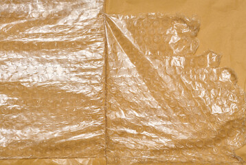 Texture of yellow paper with film and air bubbles, packaging material for transportation.