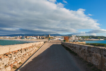 Obraz premium Scenic View of Tarifa with Stone Pathway and Prominent Tower