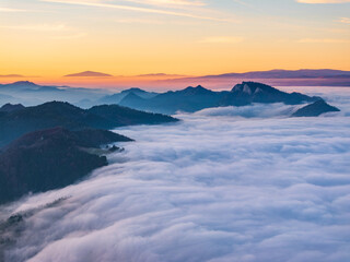 Naklejka premium Mountains above clouds at sunrise