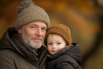 Obraz premium An elderly man and a young child share a heartfelt moment outdoors, both wearing cozy fall attire, symbolizing family bonds and intergenerational connection.
