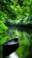 A black canoe is floating on a river with green trees in the background