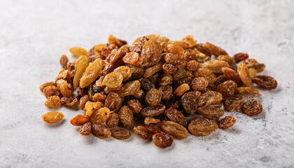 Obraz premium Heap of dried raisins on light backdrop. Dried grapes, sweet and chewy. Organic snack. Tasty food.