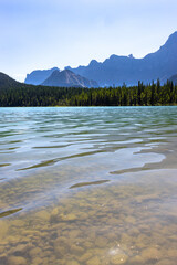 clear lake in the mountains between Banff and Jasper Alberta Canada on sunny summer day