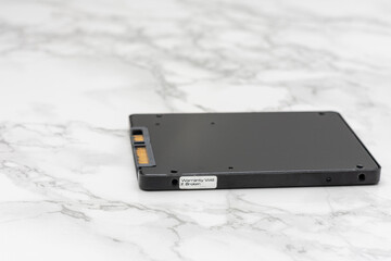 Black computer hard drive sits on a white marble countertop