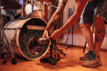 Close up sound engineer adjusting microphone for drums recording in studio