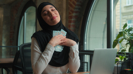 Islamic muslim Arabian ethnic woman in hijab happy girl rich wealthy businesswoman business lady female employee financial accountant count money cash finance budget satisfied gain salary in office