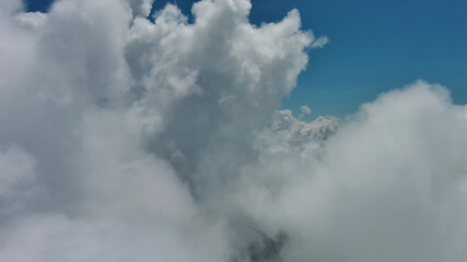 Obraz premium Flying through white fluffy clouds