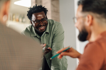 Smiling businessman leading a discussion with colleagues in a modern office
