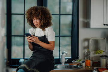 Chef using smartphone in restaurant kitchen during break time