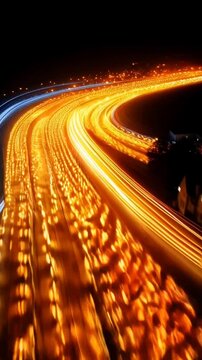 Red and yellow lights on a dark background move in an arc with a blur, resembling car traffic at night