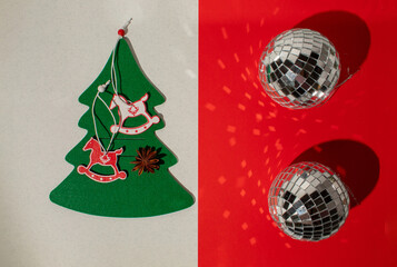 Christmas tree with angels and Christmas disco baubles on red and white background. Minimal flat lay composition
