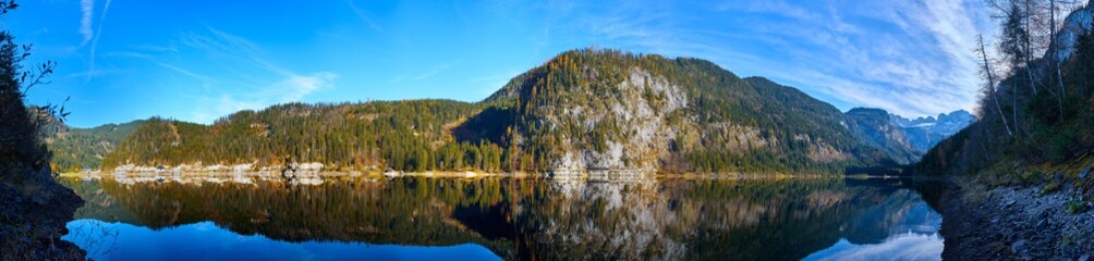 Beautiful Gosausee lake landscape with Dachstein mountains, forest, clouds and reflections in the water in Austrian Alps. Salzkammergut region