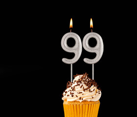 Number 99 shaped candles - Birthday cupcake on black background.