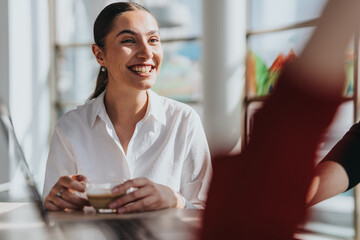 A cheerful businesswoman enjoying a coffee break in a bright office kitchen. The ambiance is...