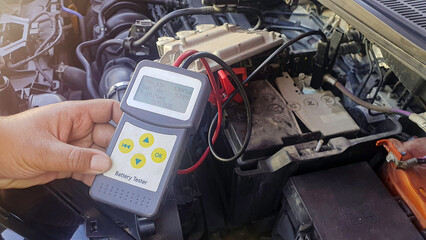 Technician service to check car battery with digital device, CCA Battery tester analyzer, automotive vehicle voltage battery maintenance