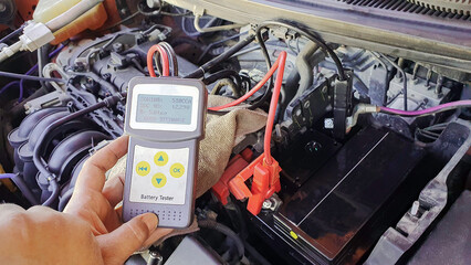 Technician service to check car battery with digital device, CCA Battery tester analyzer, automotive vehicle voltage battery maintenance