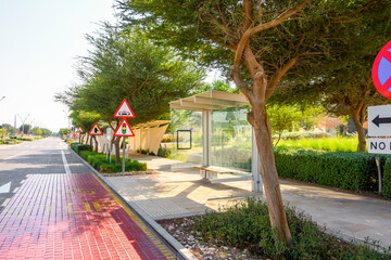 glass-fronted bus stop on the sidewalk at the side of the street