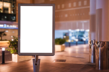 illuminated billboard on the sidewalk in front of the shopping mall