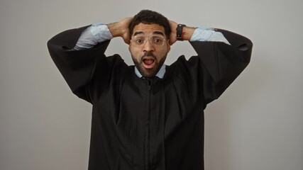 Judge in gown, young hispanic man standing with hands on head, crazy and scared with shocked mouth open in surprise over isolated white background - Powered by Adobe