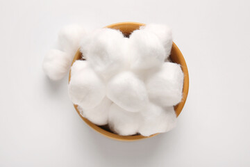 Bowl with cotton balls on white background