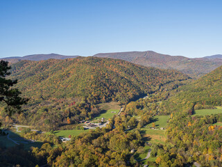 View from Seneca Rocks over the mountains in fall colors, blue sky and houses below in West...