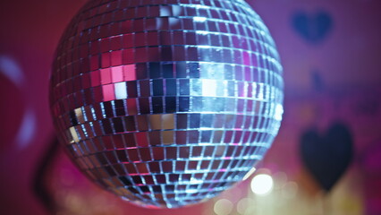 Disco ball rotating nightclub radiating glitter rays closeup. Dance celebration